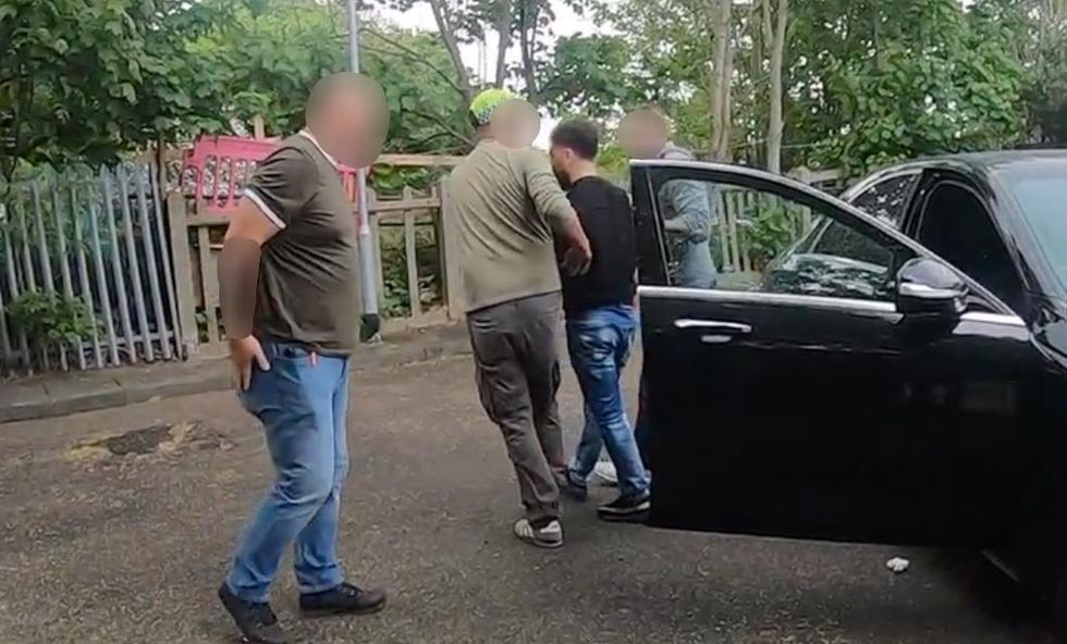 EDITORS NOTE IMAGE BLURRED AT SOURCE Handout photo dated 04/05/22 issued by the National Crime Agency (NCA) of 29-year-old Hewa Rahimpur, originally from Iran but now living in Ilford, being detained in an NCA operation in Wanstead Park, east London. Rahimpur is wanted by the authorities in Belgium, where he is suspected of being a leading figure in a network said by prosecutors to be engaged in %22systematic human smuggling%22 offences using small boats. Issue date: Thursday May 5, 2022.