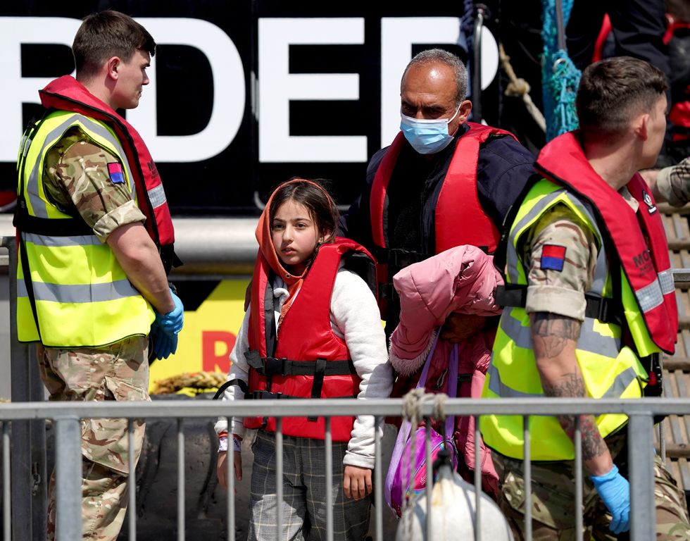 EDITORS NOTE The PA Picture Desk has been unable to gain the necessary permission to photograph children under 16 on issues involving their welfare A young girl amongst a group of people thought to be migrants as they are brought in to Dover, Kent, following a small boat incident in the Channel. Picture date: Tuesday May 17, 2022.