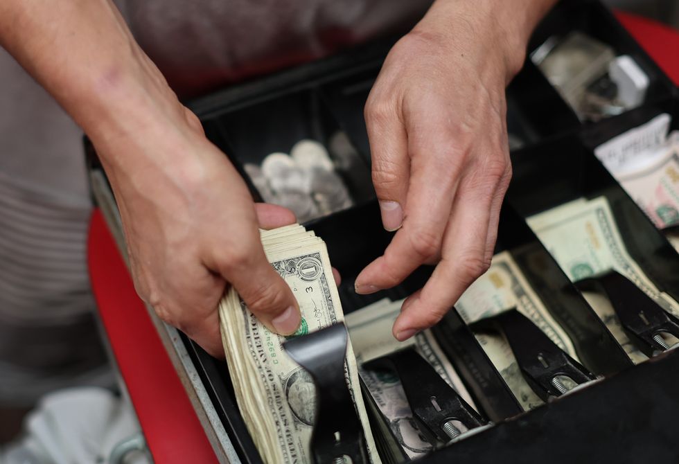Edwin Lopez sorts the money in the cash register at Frankie's Pizza on January 12, 2022 in Miami, Florida