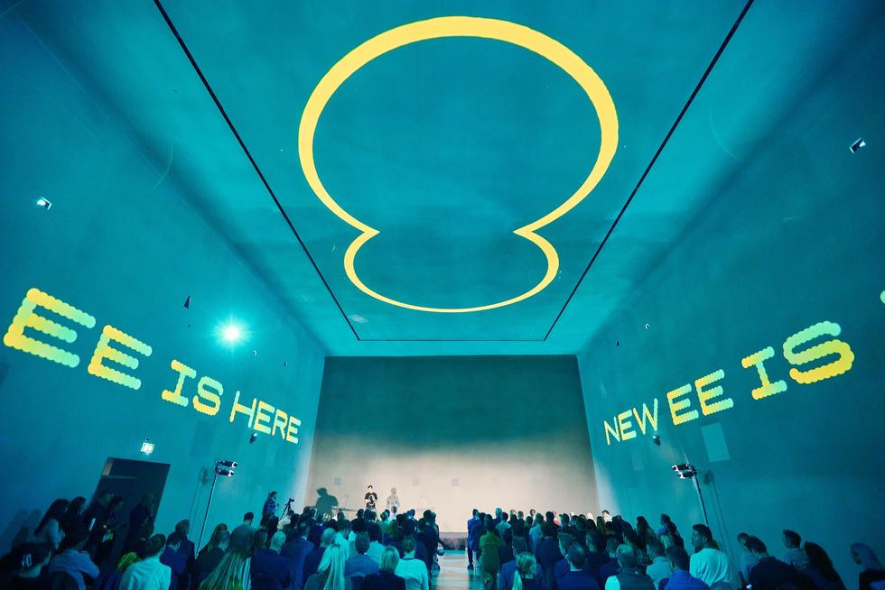 ee announces its new plans in an event space with ee branding on the wall and logos everywhere  