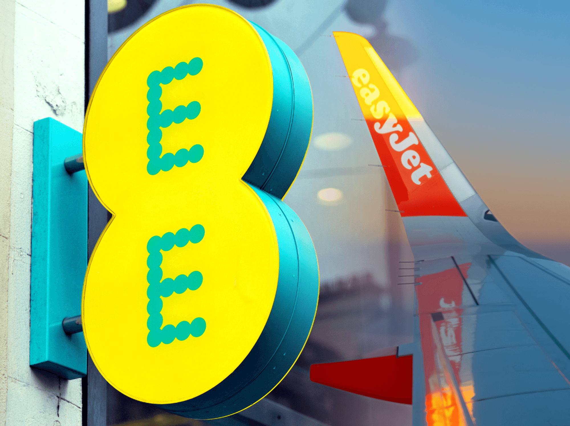 EE logo pictured outside one of its high street stores with the wing of an easyjet plane pictured omn the right side