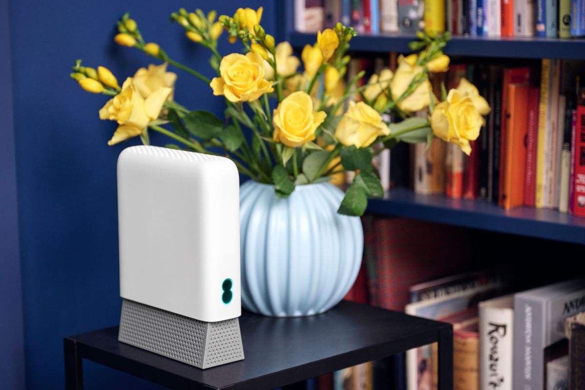 ee Smart Wi-Fi Pro pictured with a blue wall behind it and books