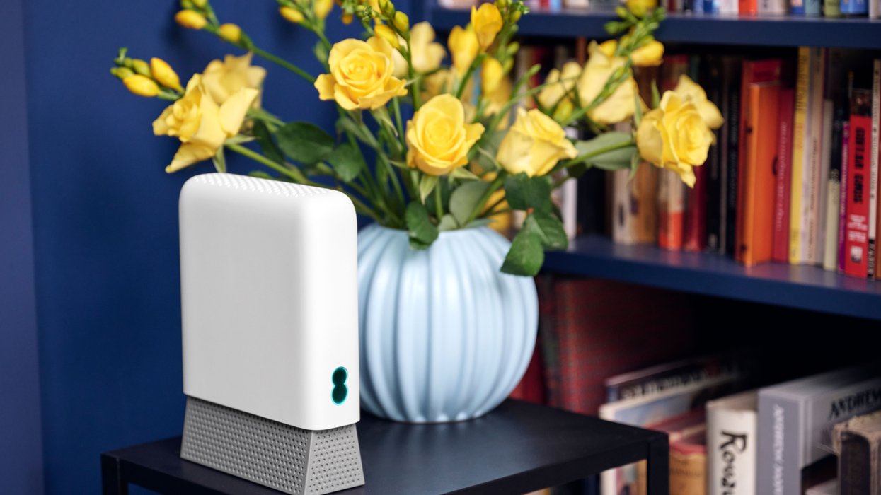 ee Smart Wi-Fi Pro pictured with a blue wall behind it and books