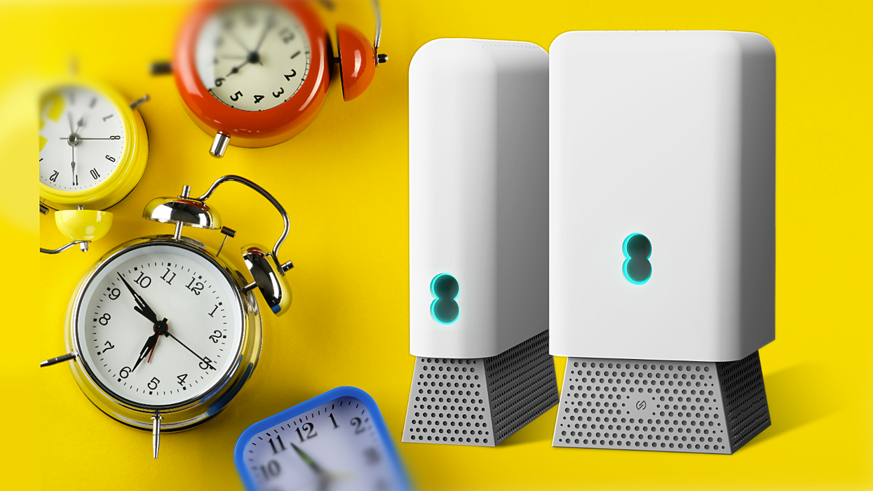 EE Wi-Fi 7 Router pictured side-by-side with the wireless booster surrounded by alarm clocks