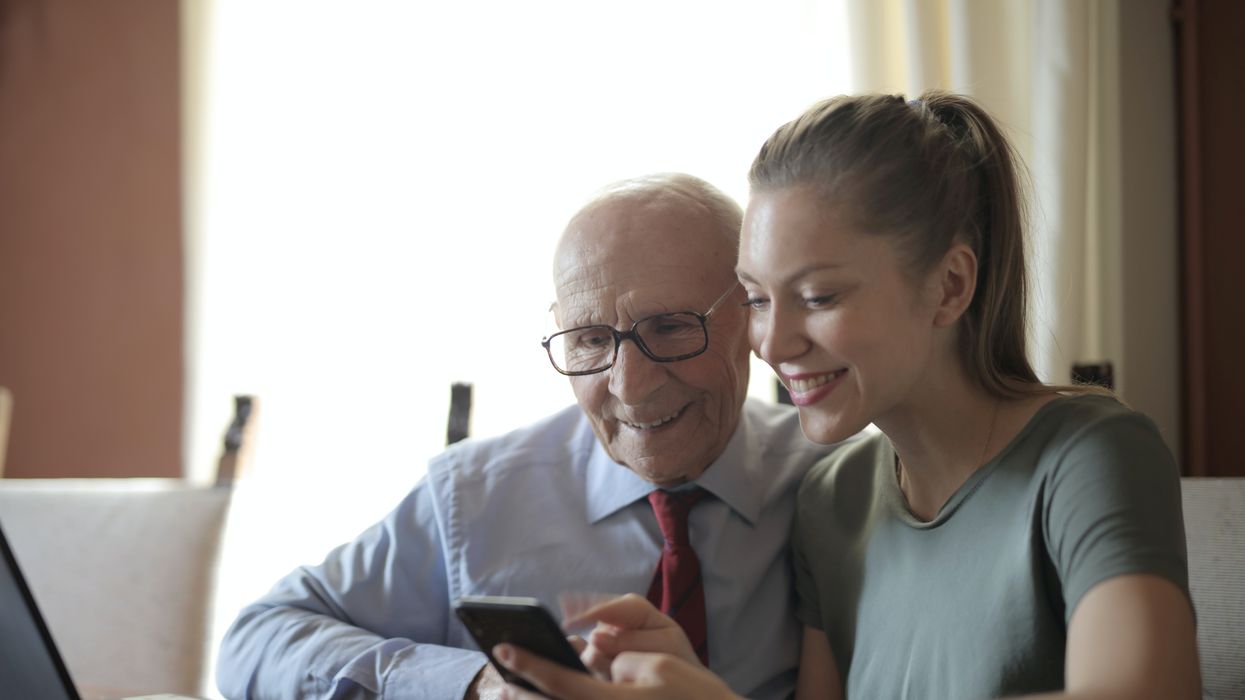 Elderly man looking a phone with a woman