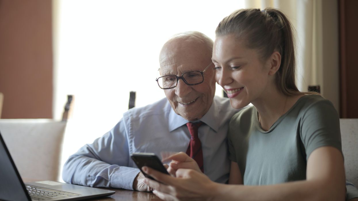 Elderly man looking a phone with a woman
