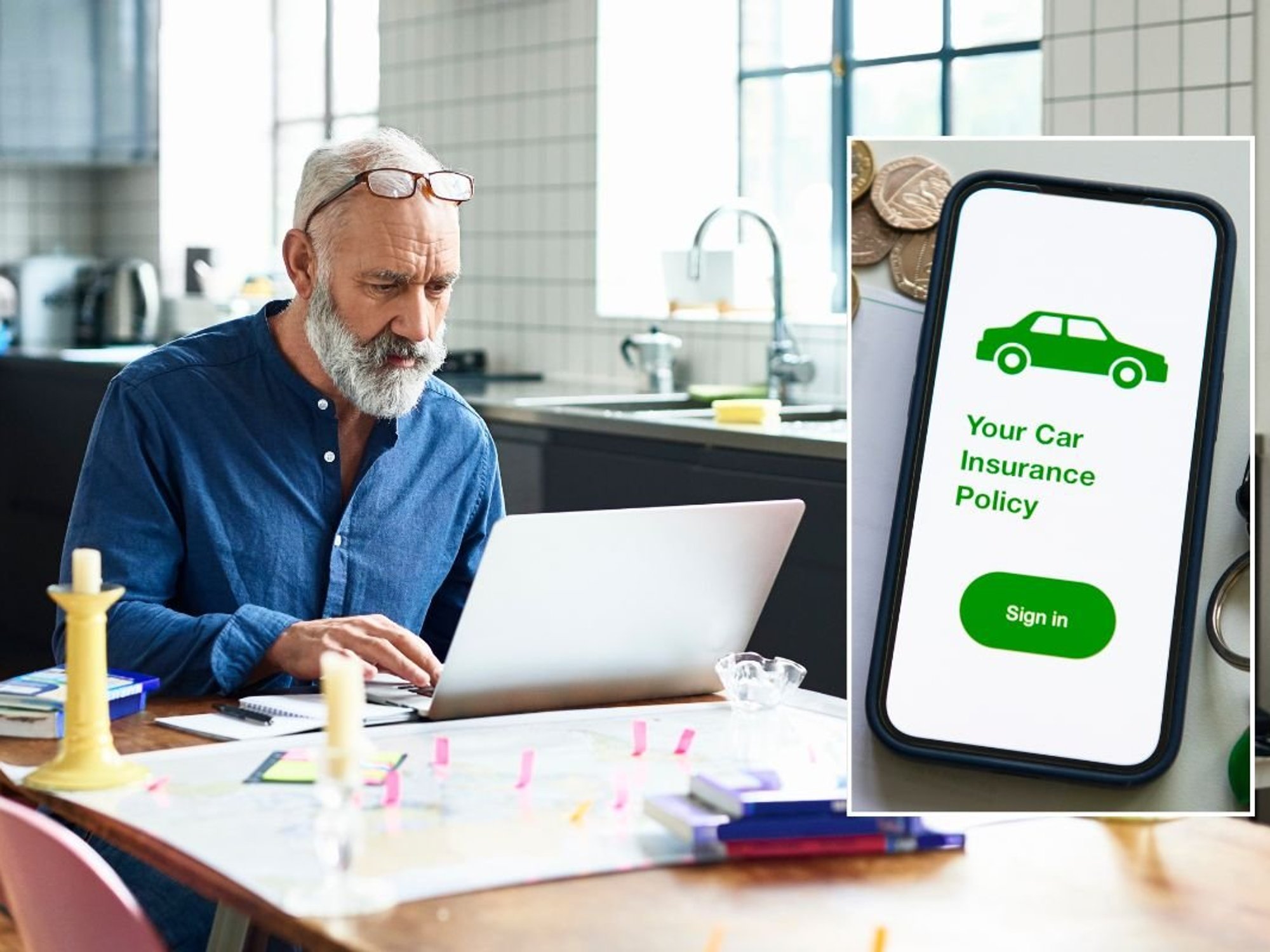 Elderly man looking at a laptop and a car insurance policy