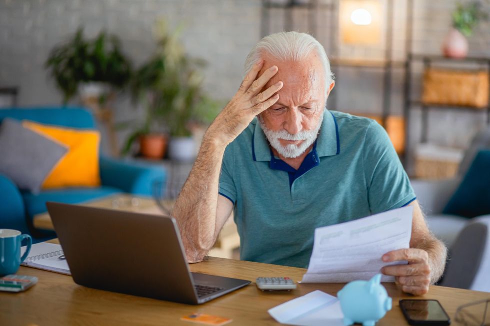 Elderly man looking at car insurance policy