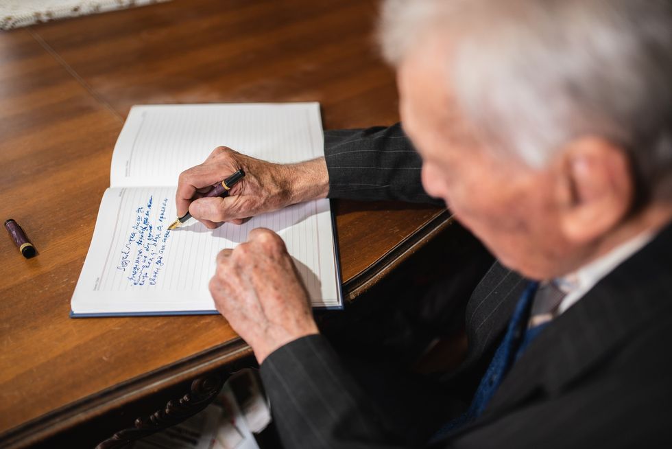 Elderly man writing in journal