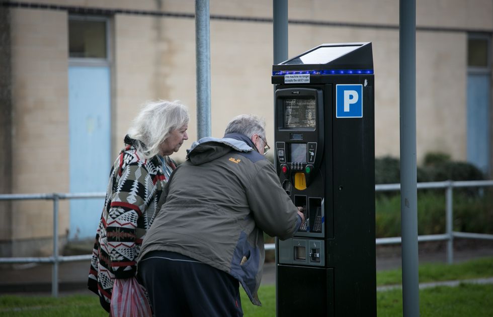 Elderly people paying for parking