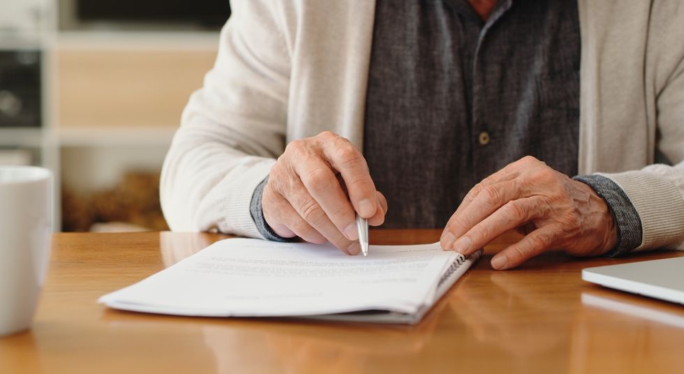 Elderly person signing document