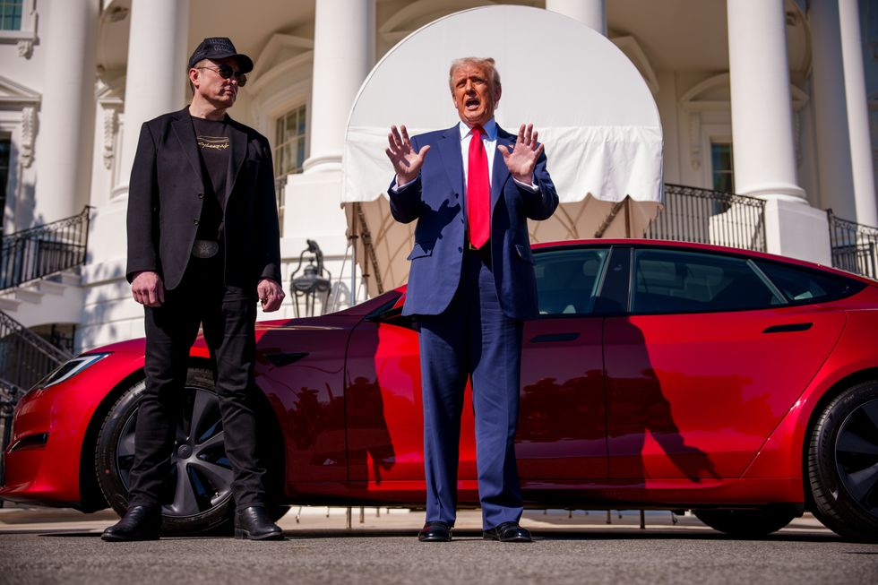 Elon Musk and Donald Trump stand in front of a Tesla Model S at the White House