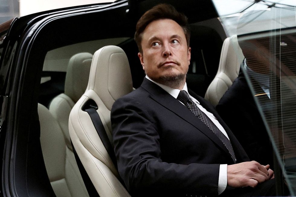 Elon Musk pictured sat in a tesla sports car