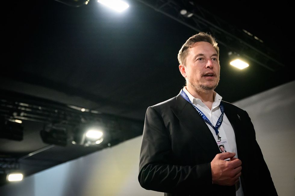 elon musk pictured with a lanyard during the ai conference in the UK