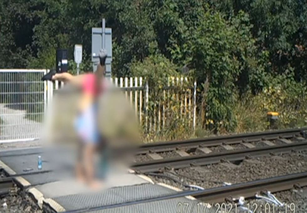 EMBARGOED TO 0001 MONDAY NOVEMBER 29 Handout CCTV grab dated 17/07/21 issued by Network Rail of a teenage girl doing a handstand at a level crossing. The incident happened in Broxtowe, Nottinghamshire on a stretch of track used by trains travelling at up to 80mph. Issue date: Monday November 29, 2021.