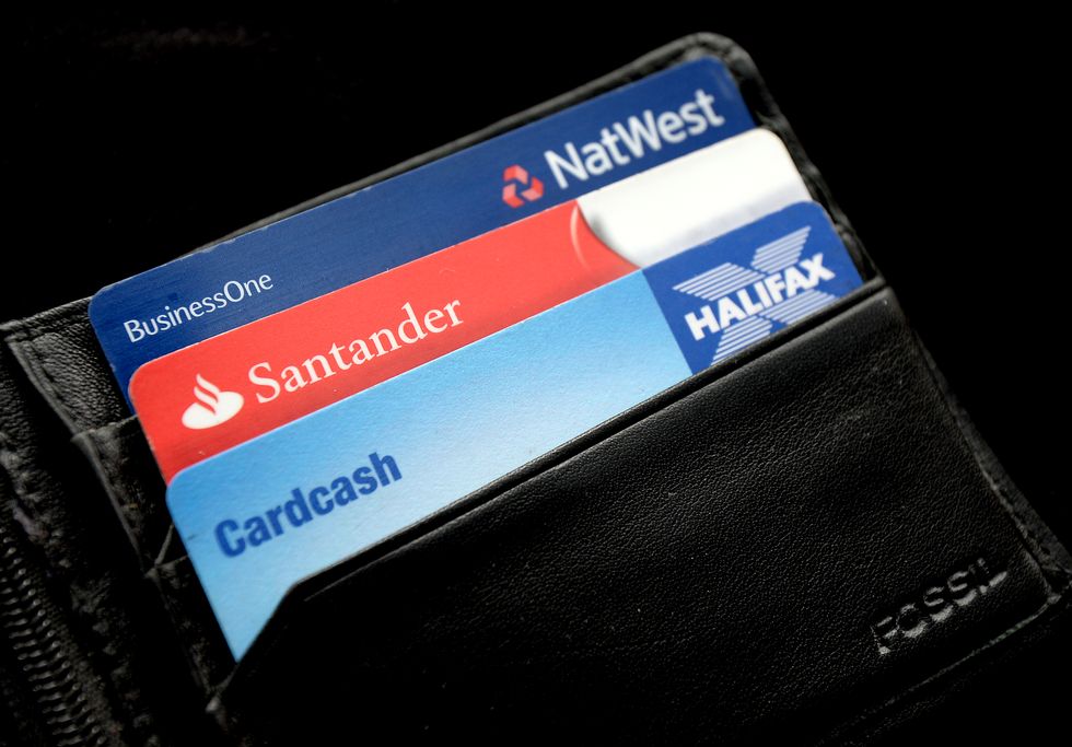 EMBARGOED TO 0001 THURSDAY SEPTEMBER 29 File photo dated 03/09/13 of a general view of a Halifax, Santander and NatWest bank cards in a wallet, as banks and building societies will have stronger incentives to prevent scams happening in the first place, as well as having to reimburse victims who have been tricked into transferring money to a fraudster, under a regulator's proposals.