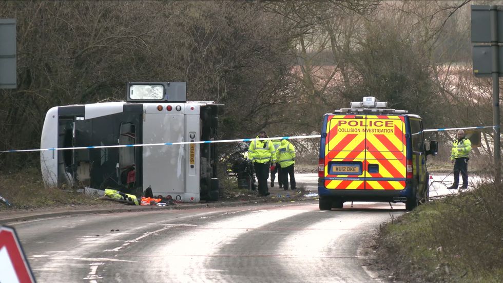 Emergency services remain at the scene after a double decker bus overturned