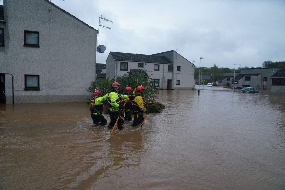 Emergency workers wade through flood water in Brechin, Scotland