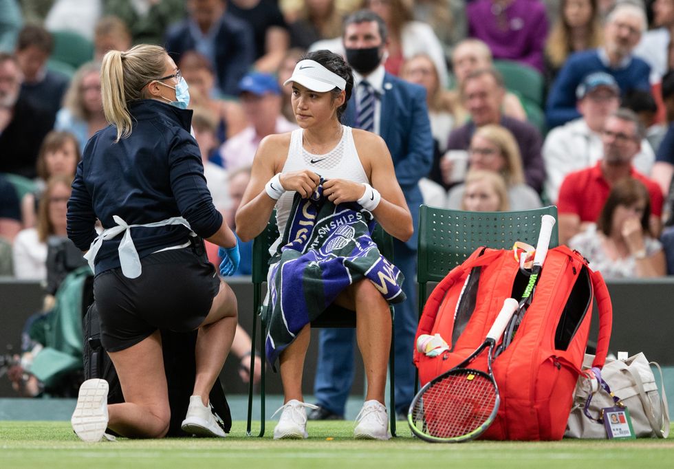 Emma Raducanu receives treatment during a medical time out in the match against Ajla Tomljanovic on day seven of Wimbledon