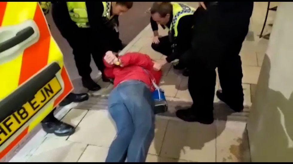 Emma Smart being restrained by police