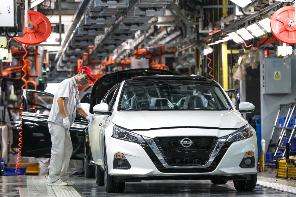 Employees work on the assembly line of Altima sedan at the Xiangyang plant of Dongfeng Nissan Passenger Vehicle Company