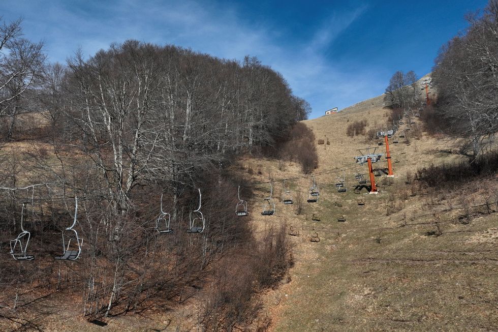Empty chairlifts above snow-free slopes