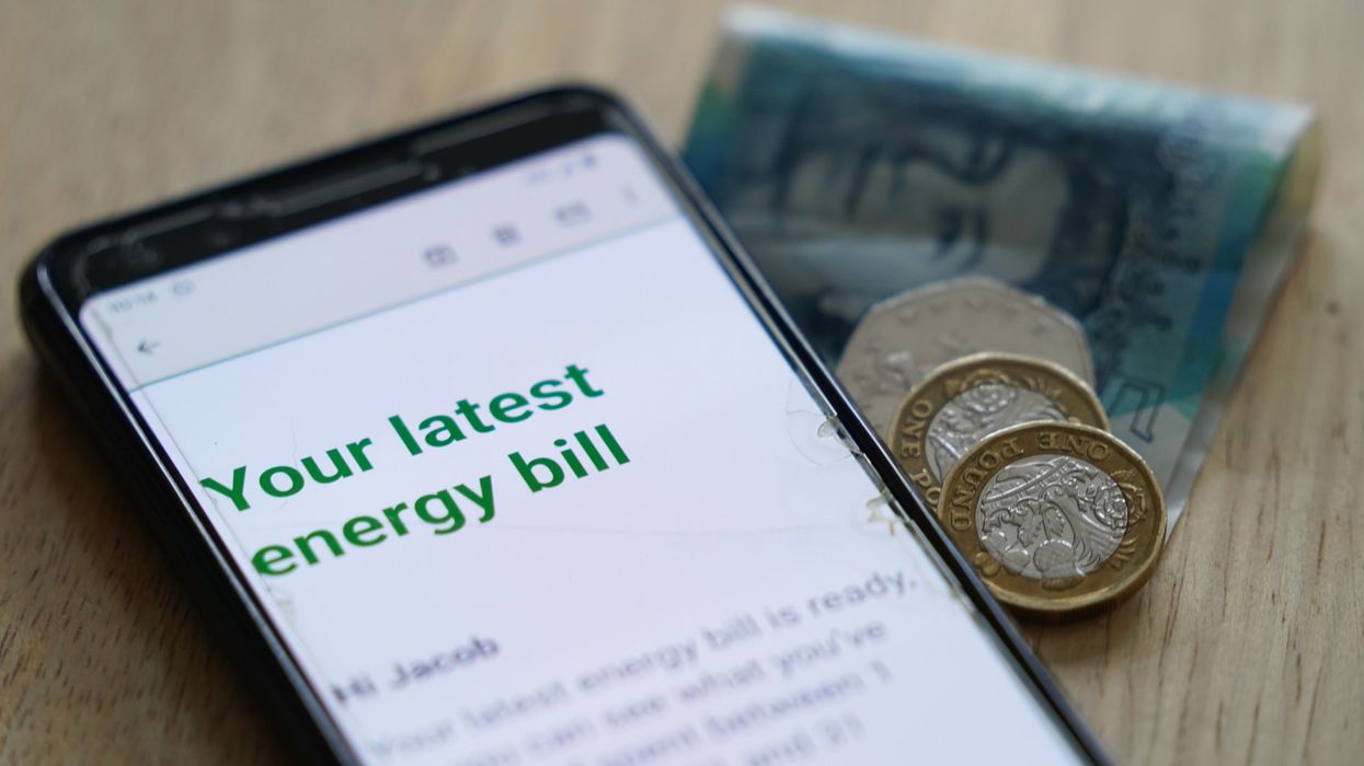 Energy bills on phone beside some money