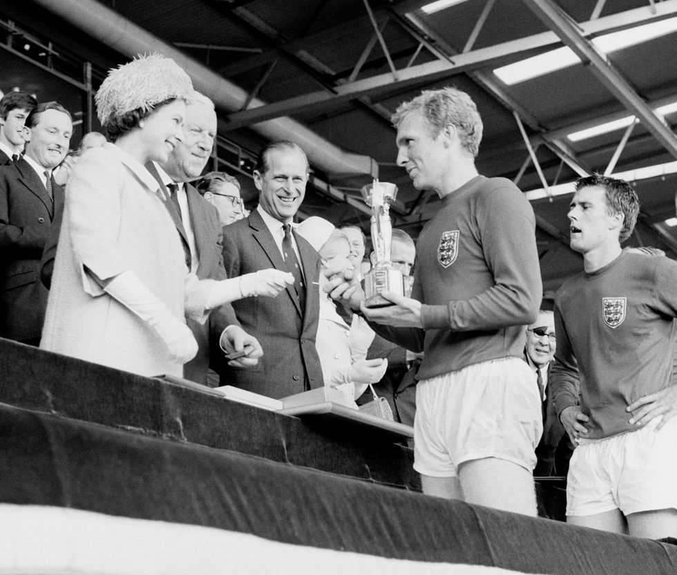 England captain Bobby Moore holding the Jules Rimet Trophy, collected from Queen Elizabeth II, after beating West Germany in the 1966 World Cup Final.