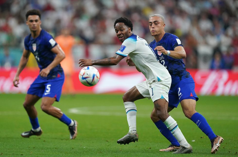 England's Raheem Sterling (centre) and USA's Sergino Dest battle for the ball during the FIFA World Cup Group B match at the Al Bayt Stadium in Al Khor, Qatar. Picture date: Friday November 25, 2022.