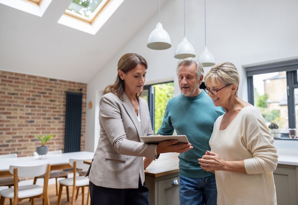 Estate agent with couple in kitchen during the day