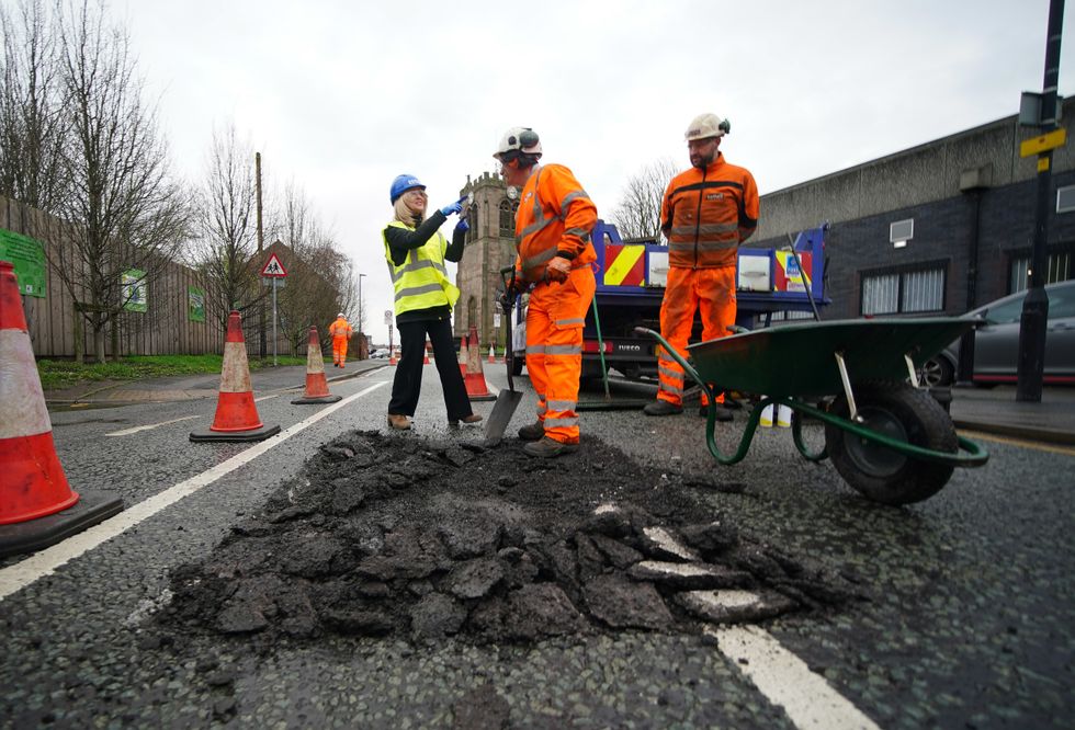 Esther McVey filling in a pothole