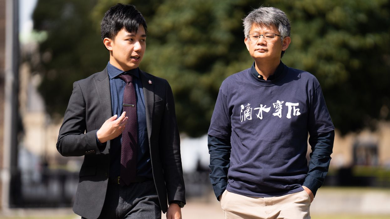 Exiled activists Finn Lau (left) and Christopher Mung (right) walk through College Green, London