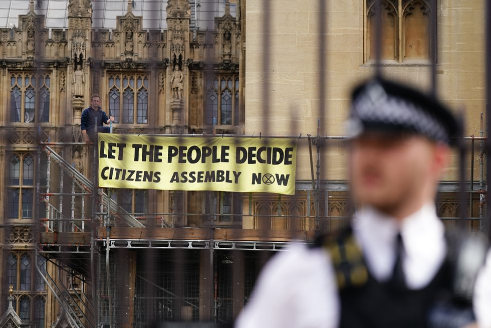 Extinction Rebellion protesters demonstrating on scaffolding, erected for renovation work, outside the Houses of Parliament, Westminster, calling for a Citizen's assembly. The campaign group says supporters have also superglued themselves around the Speaker's chair in the House of Commons chamber. Picture date: Friday September 2, 2022.