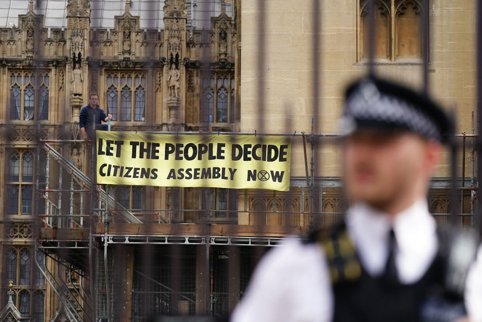 Extinction Rebellion protesters demonstrating on scaffolding, erected for renovation work, outside the Houses of Parliament, Westminster, calling for a Citizen's assembly.