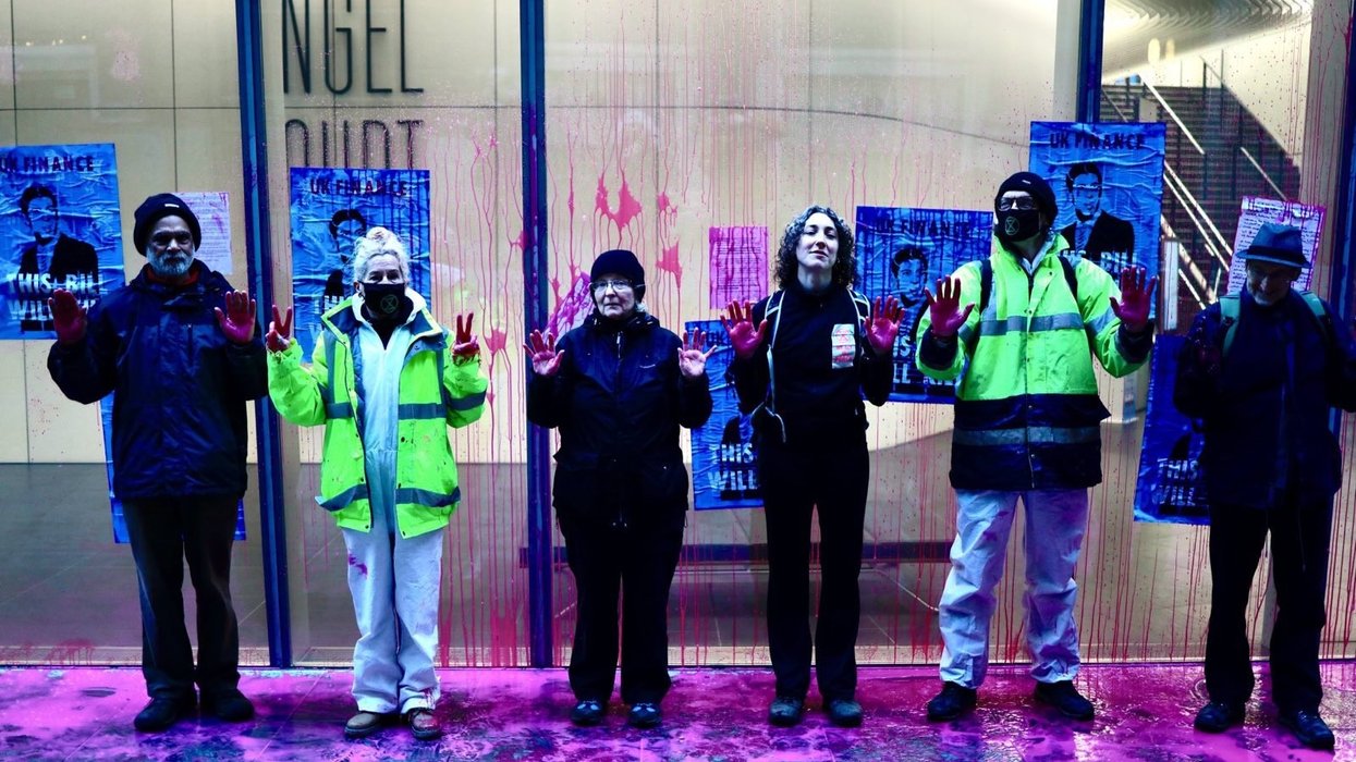 Extinction Rebellion protesters pose for a photo outside UK Finance after covering the building in pink paint.