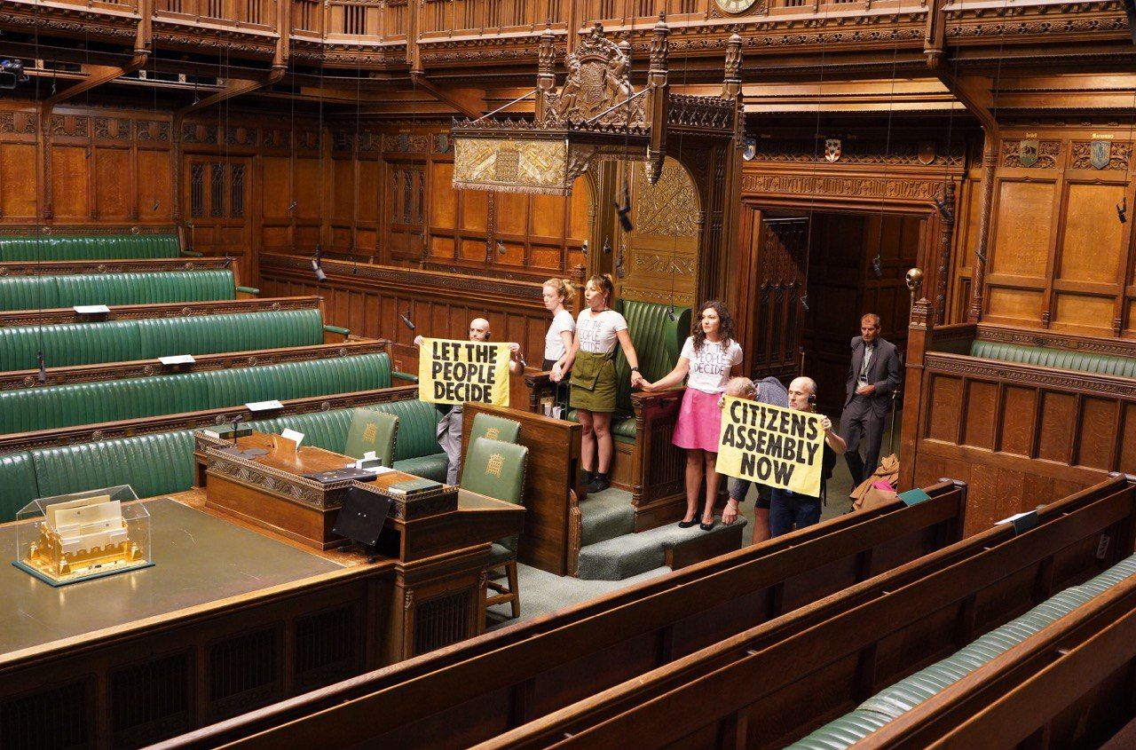 Extinction Rebellion protesters super glue their hands together around the Speaker's chair.