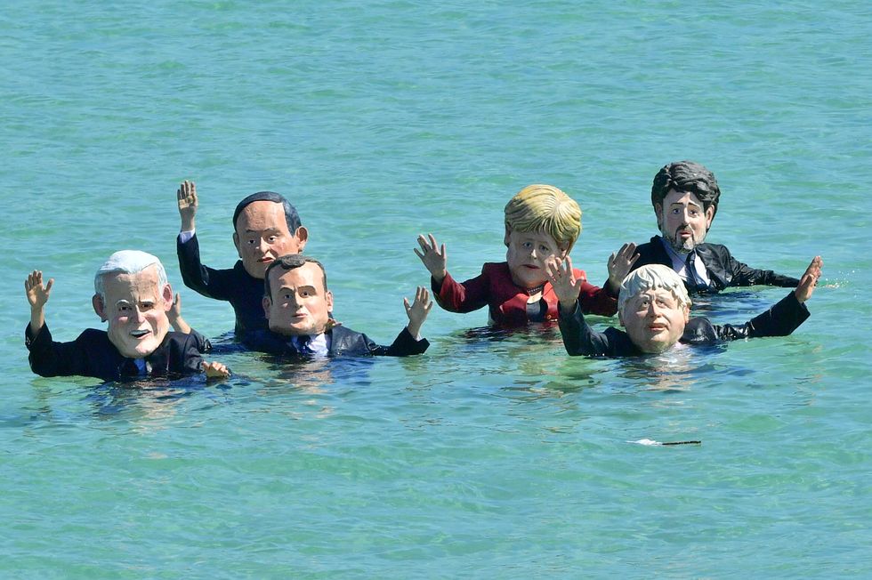 Extinction Rebellion protesters, wearing masks of G7 leaders, in the sea of the beach at St Ives, during the G7.