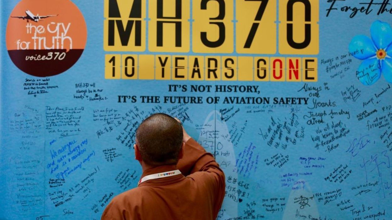 Families write on the memorial wall for victims of MH370