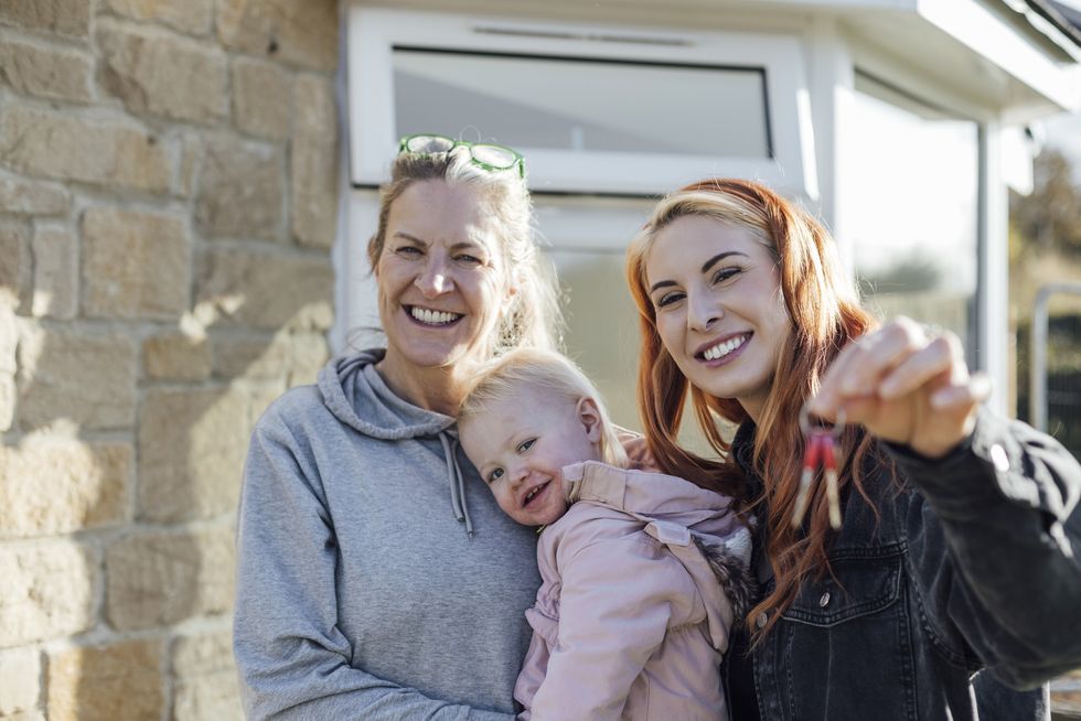 Family moving into a house, woman holding keys