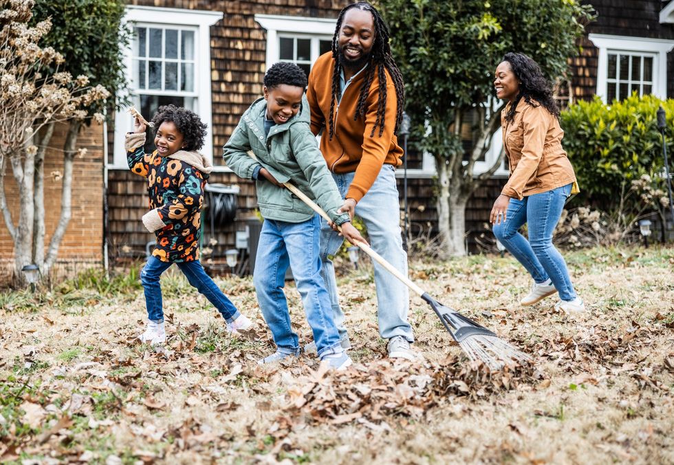 Family raking leaves in their garden