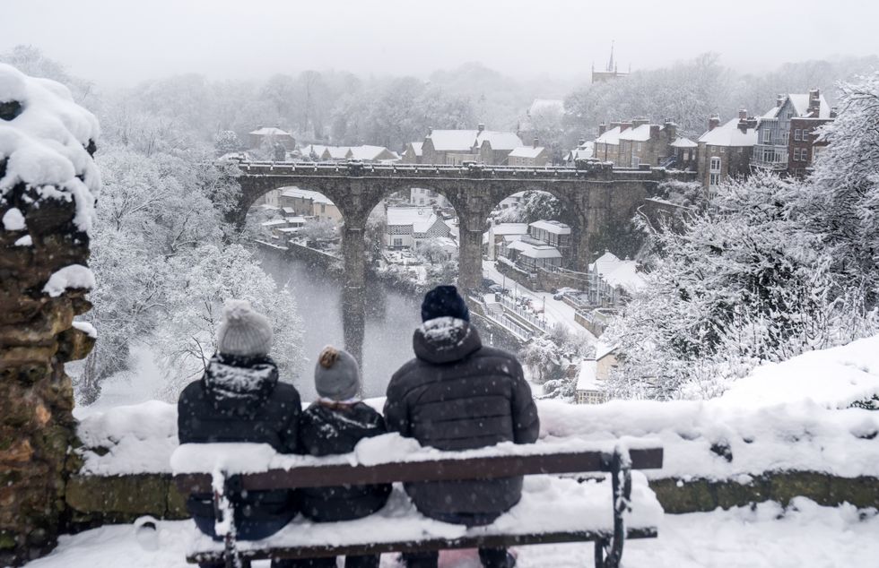 Family sits on bench in the snow