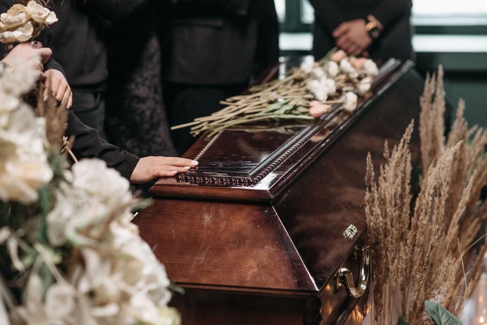 Family touching a coffin