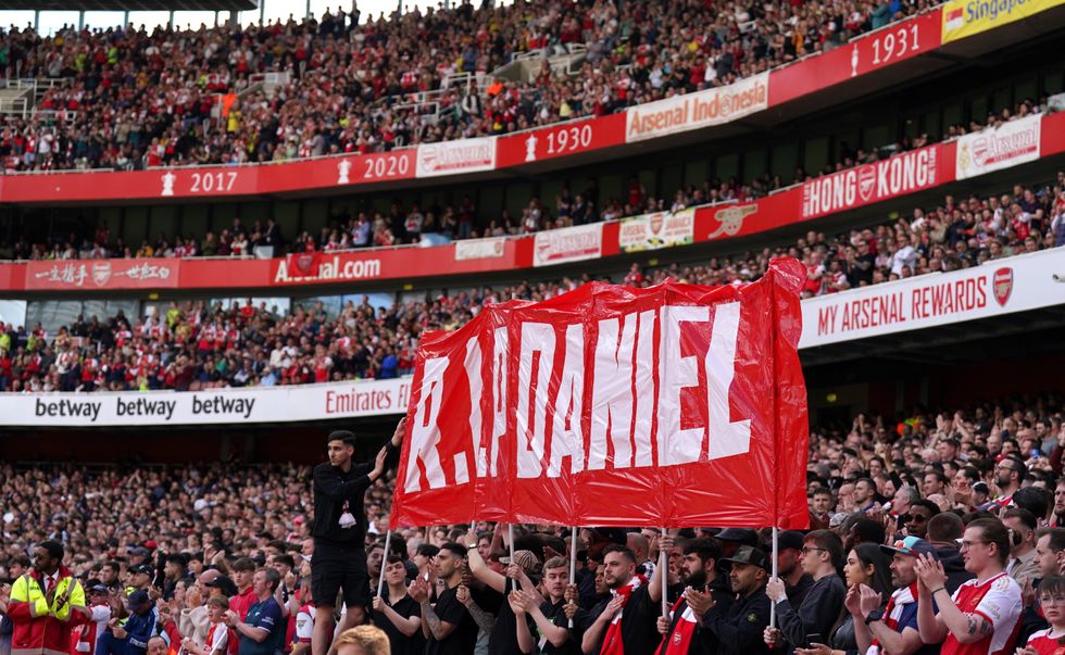 Fans hold up a banner on the 14th minute in memory of 14-year-old Daniel Anjorin