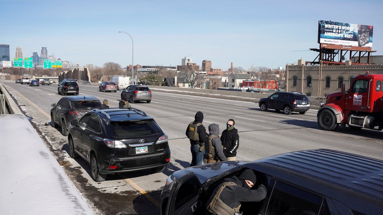 Federal immigration agents stand at Interstate 35W, while conducting immigration enforcement tasks in Minneapolis