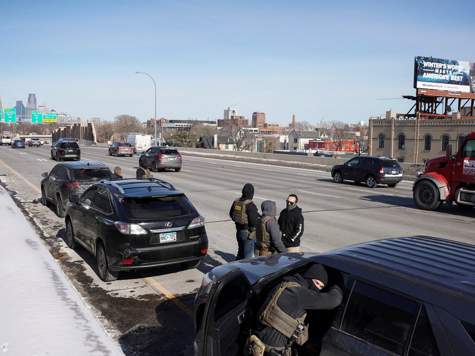 Federal immigration agents stand at Interstate 35W, while conducting immigration enforcement tasks in Minneapolis