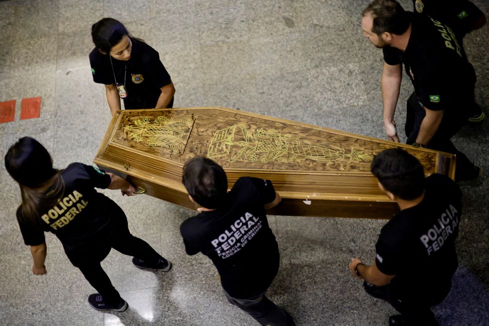 Federal Police officers carry a coffin containing human remains after a suspect confessed to killing British journalist Dom Phillips and Brazilian indigenous expert Bruno Pereira and led police to the location of remains, at the headquarters of the Federal Police, in Brasilia, Brazil