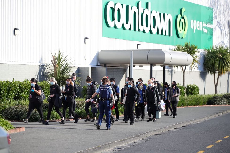 FILE PHOTO: A police officer leads employees of a nearby store away from the scene of an attack carried out by a man who injured multiple people at a shopping mall in Auckland, New Zealand, September 3, 2021.  Stuff Limited/Ricky Wilson via REUTERS/File Photo