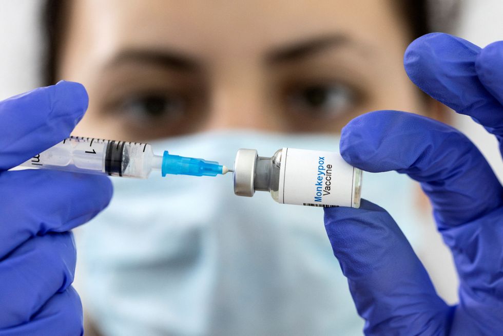 FILE PHOTO: A woman holds a mock-up vial labeled %22Monkeypox vaccine%22 and medical syringe in this illustration taken, May 25, 2022. REUTERS/Dado Ruvic/Illustration/File Photo