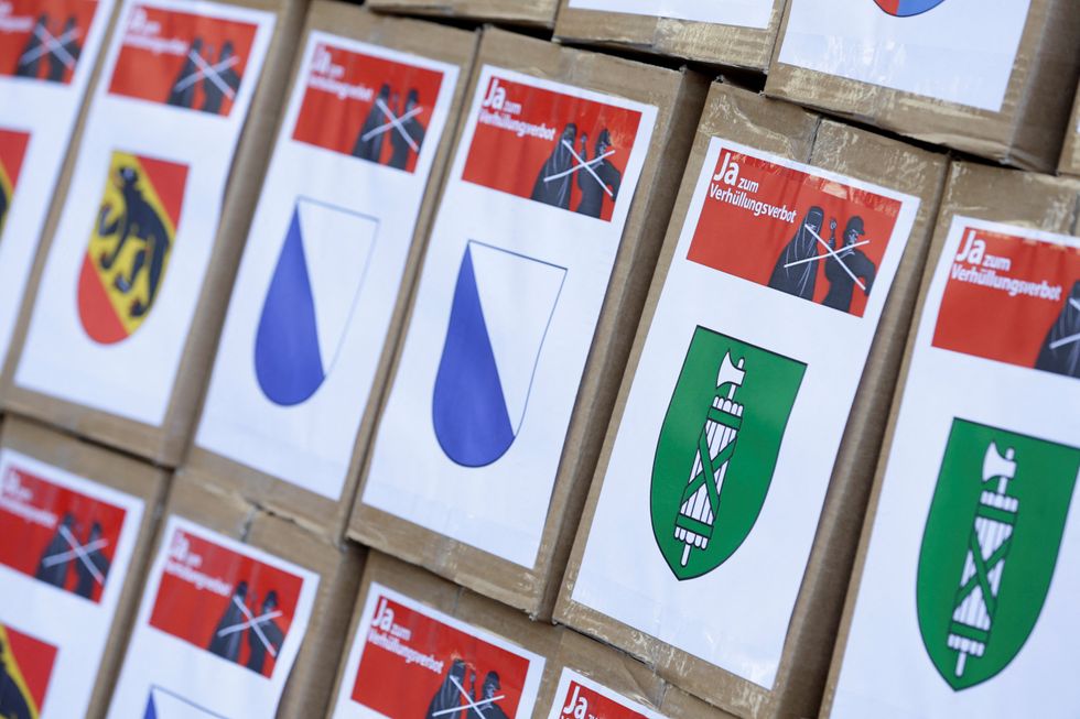 FILE PHOTO: Boxes from the committee for %22Yes to a Mask Ban%22 (Ja zum Verhuellungsverbot), containing more than 100,000 signatures collected that are required to put the proposal of a ban on facial coverings worn by some Muslim women to a national vote, are seen at the Federal Chancellery in Bern, Switzerland September 15, 2017. REUTERS/Moritz Hager/File Photo