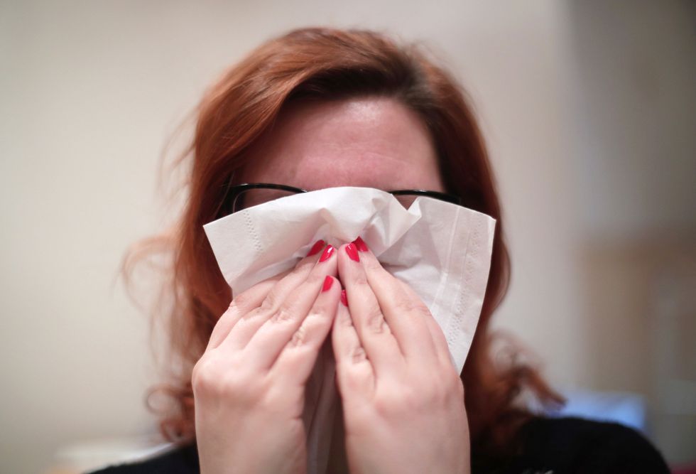 File photo dated 10/01/18 of a woman blowing her nose with a tissue. While some people will welcome the warmer weather, for others the unusual temperatures will wreak havoc with their hay fever symptoms. Issue date: Wednesday March 23, 2022.